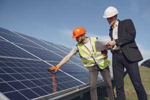 Two officials inspecting solar panels